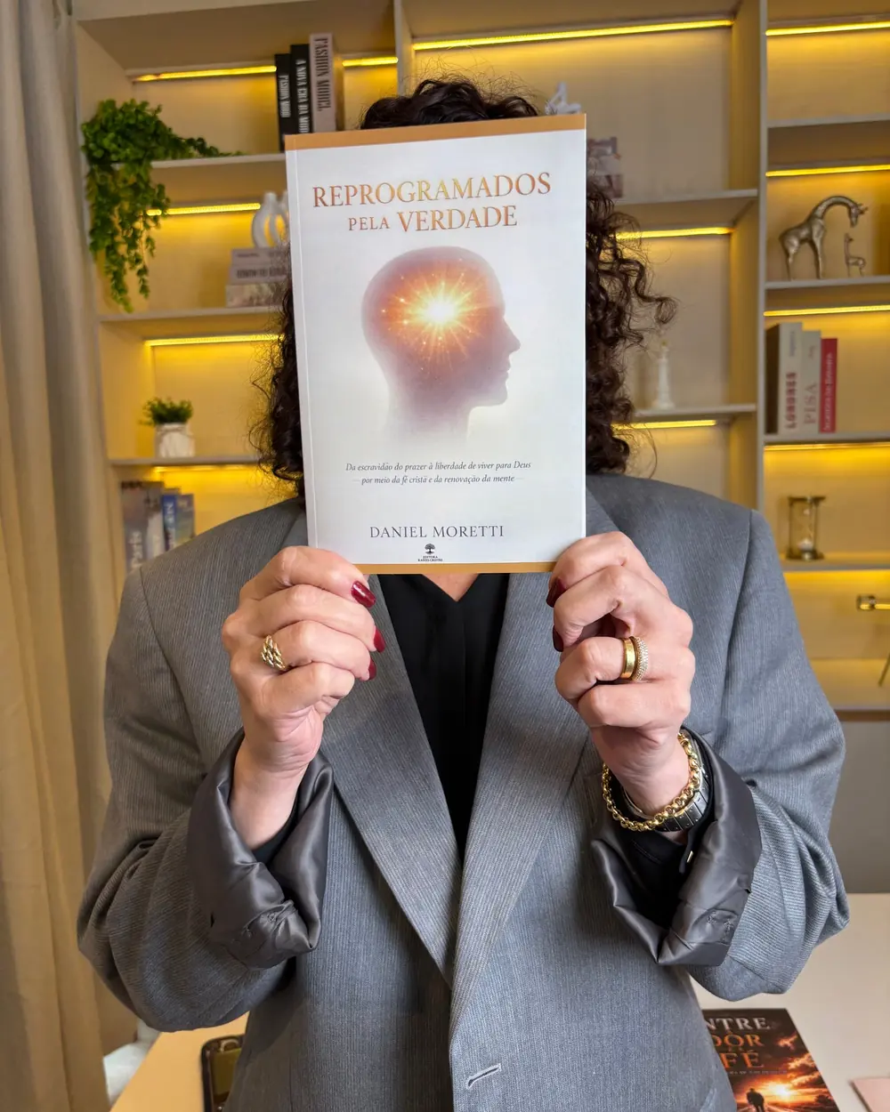 Leitora segurando o livro Reprogramados pela Verdade